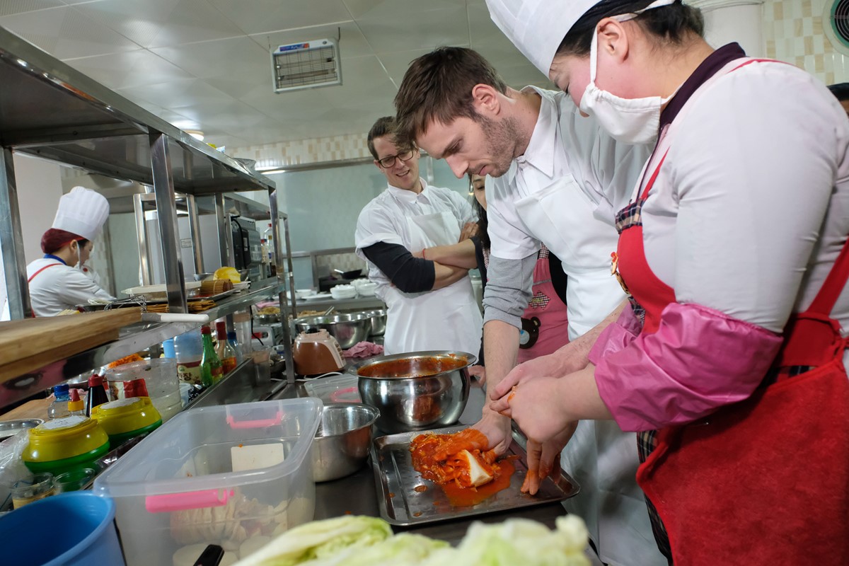 Hier lernt der Profi von den Studierenden, die ihn in die Kunst des Kimchi einführen. Milchsäurevergorenes Gemüse ist das Herz der koreanischen Küche.